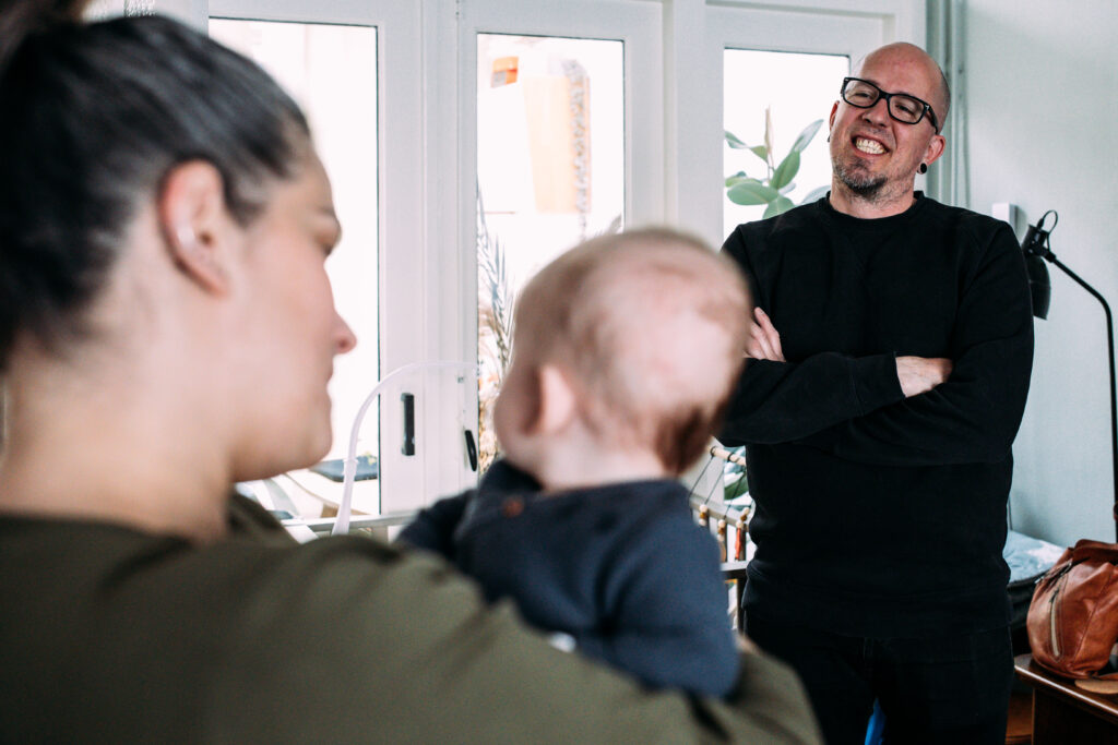 Familiefotografie Eindhoven trotse vader kijkt naar moeder en zoon