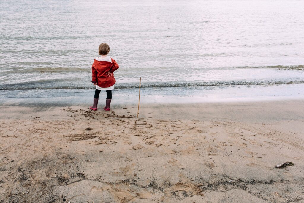 Familiefotografie Eindhoven meisje staat met hand in de zij aan de waterlijn