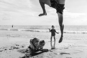Familiefotografie Eindhoven Vader springt over kind heen op het strand